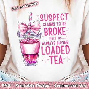 May include: A white t-shirt with a pink and white illustration of a glass of iced tea with a pink bow and straw. The text on the shirt reads "Suspect claims to be broke but is always buying loaded tea".