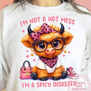 May include: White sweatshirt with a graphic of a cartoon cow wearing glasses, a bow, and a bandana. The text reads "I'M NOT A HOT MESS I'M A SPICY DISASTER." A pink purse and sneakers are also in the image.