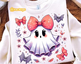 May include: A cream-coloured crewneck sweatshirt featuring a central graphic of a white ghost with a large pink bow, surrounded by small pink flowers, two purple bats, and two additional pink bows, with the text 9 Free Designs in the upper left corner.