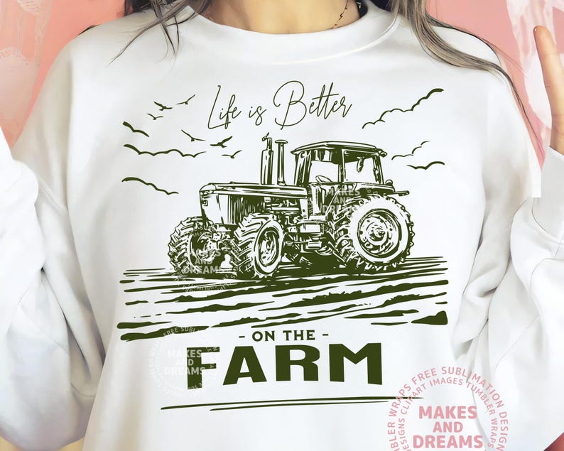 May include: White sweatshirt with a green tractor graphic and the text "Life is Better - On The Farm." The design includes birds and a field, perfect for farm enthusiasts.