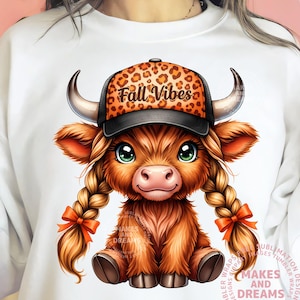 Può includere: Illustrazione digitale di un vitello di mucca delle Highlands con un berretto da baseball nero e leopardato con le parole "Fall Vibes". Il vitello ha lunghi capelli intrecciati con fiocchi arancioni e grandi occhi verdi. Il vitello è seduto.