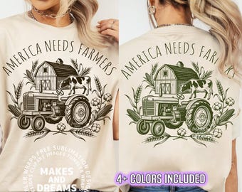 Könnte beinhalten: Beigefarbenes T-Shirt mit einem Aufdruck, der einen Traktor, eine Scheune, eine Kuh und den Text "AMERICA NEEDS FARMERS" zeigt. Das Design enthält Weizen, Mais und Baumwolle. Der Schriftzug "MAKES AND DREAMS" ist ebenfalls sichtbar.