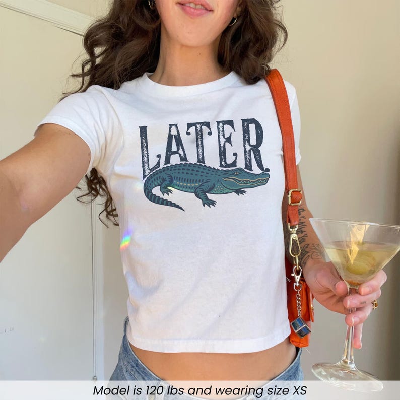 Woman wearing white "Later Gator" Vintage 90s Y2K Baby Tee.