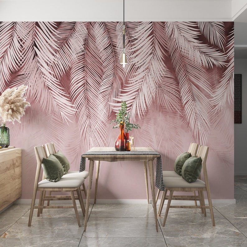 Pu&ograve; includere: Una sala da pranzo con una parete rosa con una carta da parati a motivi di foglie di palma. La stanza ha un tavolo in legno con quattro sedie e cuscini verdi. Un lampadario a sospensione &egrave; sopra il tavolo.