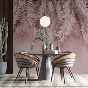 Pu&ograve; includere: Una sala da pranzo con una carta da parati a foglie tropicali rosa chiaro, un tavolo rotondo in legno con quattro sedie, una pianta di cactus in un vaso grigio e un lampadario a sospensione con un globo bianco.