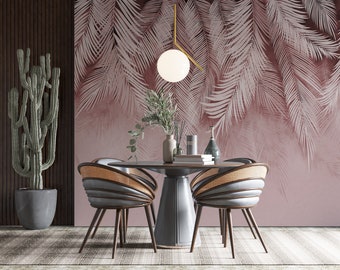 May include: A dining room with a light pink tropical leaf wallpaper, a round wooden table with four chairs, a cactus plant in a gray pot, and a hanging light fixture with a white globe.