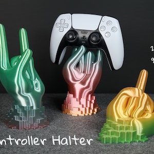 Könnte beinhalten: Drei 3D-gedruckte Hände in verschiedenen Farben halten einen weißen Videospiel-Controller. Die Hände sind in einer Rock'n'Roll-Handgeste. Der Text "Controller Halter" ist unter den Händen geschrieben. Der Text "2 Formen 9 Farben" ist in der oberen rechten Ecke des Bildes geschrieben.