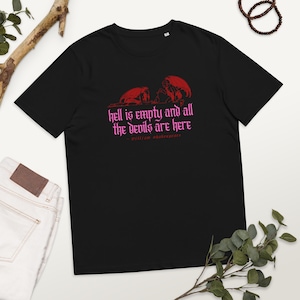 Puede incluir: Camiseta negra con un gráfico rojo de dos demonios y la cita "El infierno está vacío y todos los demonios están aquí - William Shakespeare".