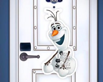 May include: A white door with a brown frame and a silver door handle. A cutout of Olaf from Frozen is attached to the door. The cutout is holding a sign that says "Once Upon a Cruise" with a blue background and gold lettering.