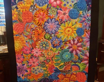 May include: A colourful quilt featuring a large bouquet of flowers in a dark purple vase. The flowers are a variety of colours, including red, orange, yellow, green, blue, and purple. The background is a dark blue with a subtle pattern.