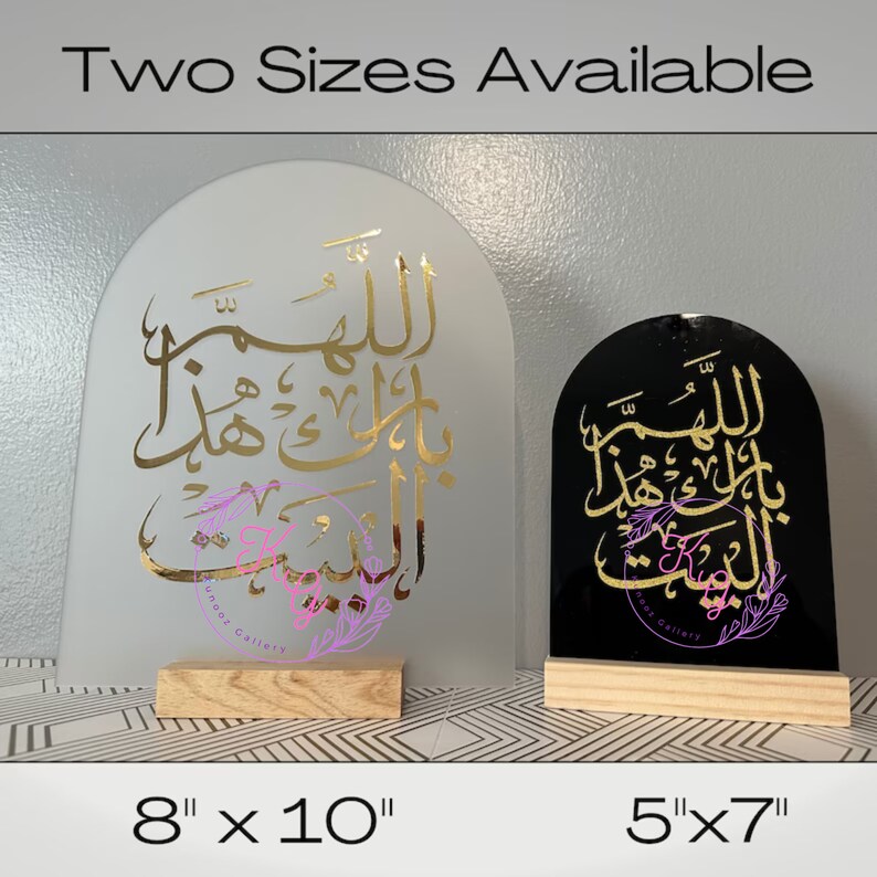 May include: Two sizes of Islamic calligraphy wall decor, one on a white background with gold lettering and the other on a black background with gold lettering. The text reads "Allahumma inni as'aluka al-bait al-bait". The larger piece measures 8 inches by 10 inches and the smaller piece measures 5 inches by 7 inches.
