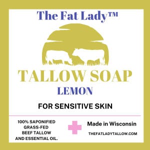 Puede incluir: Una etiqueta amarilla y blanca con el texto "The Fat Lady&trade;" y "TALLOW SOAP LEMON FOR SENSITIVE SKIN". La etiqueta tambi&eacute;n incluye una silueta de dos vacas en un campo, un signo m&aacute;s y el texto "100% SAPONIFIED GRASS-FED BEEF TALLOW AND ESSENTIAL OIL. Made in Wisconsin THEFATLADYTALLOW.COM"
