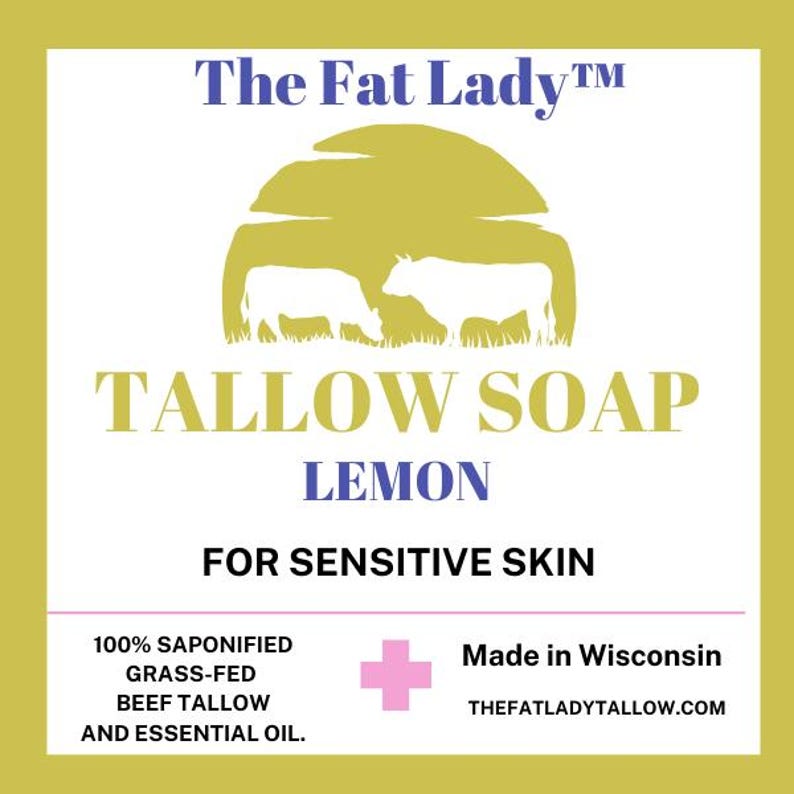 Puede incluir: Una etiqueta amarilla y blanca con el texto "The Fat Lady&trade;" y "TALLOW SOAP LEMON FOR SENSITIVE SKIN". La etiqueta tambi&eacute;n incluye una silueta de dos vacas en un campo, un signo m&aacute;s y el texto "100% SAPONIFIED GRASS-FED BEEF TALLOW AND ESSENTIAL OIL. Made in Wisconsin THEFATLADYTALLOW.COM"