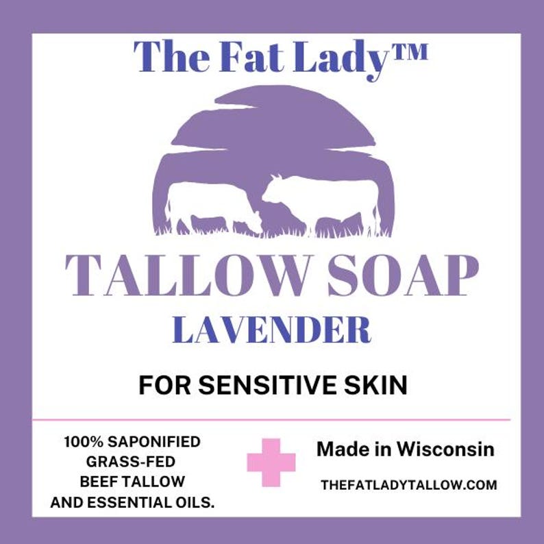 Puede incluir: Etiqueta morada y blanca para jab&oacute;n de sebo de lavanda. La etiqueta presenta una caricatura de dos vacas en un campo. El texto dice "The Fat LadyTM Tallow Soap Lavender For Sensitive Skin 100% Saponified Grass-Fed Beef Tallow and Essential Oils. Made in Wisconsin THEFATLADYTALLOW.COM"