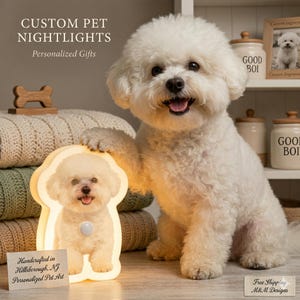 May include: A fluffy white dog poses next to a custom pet nightlight. The nightlight is shaped like a dog and has a picture of a dog on it. Text on the nightlight says "Handcrafted in Hillsborough, NJ Personalized Pet Art". The image also includes text that says "CUSTOM PET NIGHTLIGHTS Personalized Gifts".