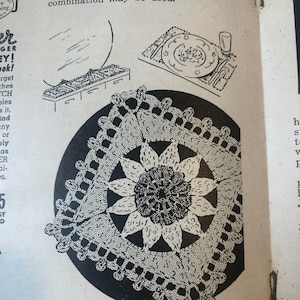 Puede incluir: Una ilustración en blanco y negro de un encaje de ganchillo con un diseño de flor en el centro. El encaje es circular y tiene un borde festoneado. La ilustración es de un patrón de ganchillo vintage.