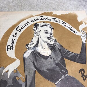 May include: A vintage advertisement for back to school and early fall fashions. The ad features a woman wearing a dark gray dress with a belt and a white blouse. The text "Back to School and Early Fall Fashions" is written in a cursive font on a brown background.