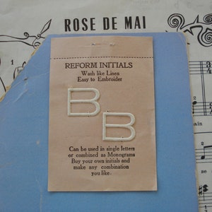 May include: Two white felt letters, both the letter B, on a light pink card with the text "Reform Initials, Wash like Linen, Easy to Embroider". The card also says "Can be used in single letters or combined as Monograms. Buy your own initials and make any combination you like."