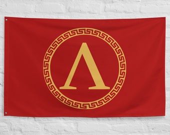 May include: A red flag with a gold Greek key border and a gold letter A inside. The letter A is a symbol of the Spartan army.