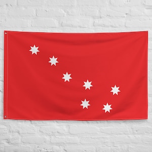 Può includere: Una bandiera rossa con sette stelle bianche a cinque punte disposte in diagonale dall'angolo in alto a sinistra all'angolo in basso a destra.