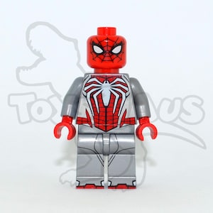 Può includere: Una minifigure LEGO di Spider-Man con testa rossa, motivi a ragnatela neri e occhi bianchi. Il busto presenta un emblema a ragno bianco su sfondo rosso e argento, con braccia e gambe argentate accentuate da mani di colore rosso.