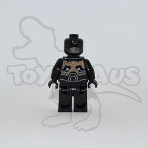 May include: Black Lego minifigure with a gold and black patterned torso and a black helmet with a silver visor.
