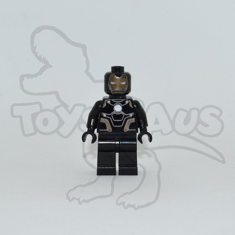May include: Black Lego minifigure of Iron Man wearing a black and gold suit with a white face mask.