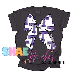 May include: A dark gray t-shirt with a purple and white bow featuring the letter "T" repeated throughout. The text "Tarleton State" is printed on the shirt.