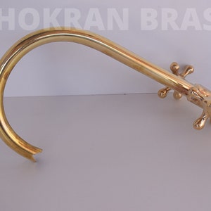 May include: A gold-colored brass faucet with a curved spout and four cross-shaped handles.