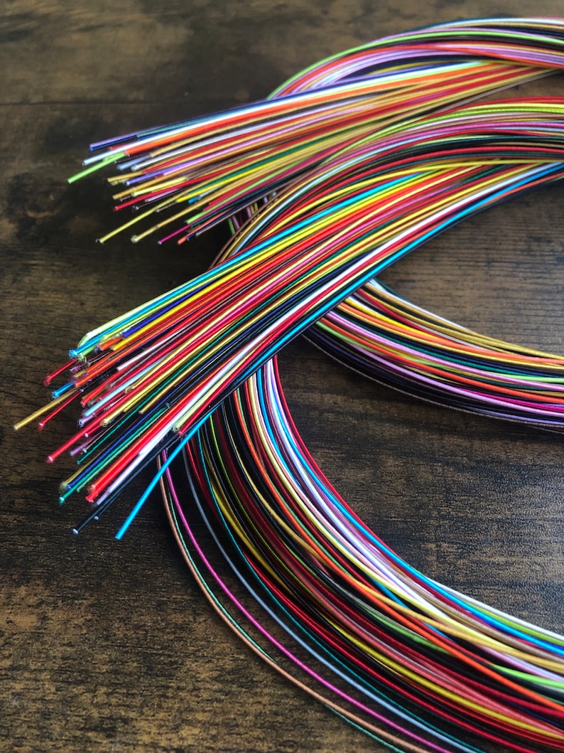 May include: A bundle of colorful, thin, metallic wires. The wires are arranged in a circle, with the ends of the wires sticking out.