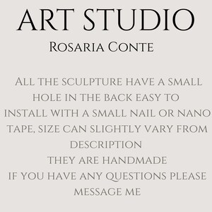 May include: Text on a light beige background reads "ART STUDIO" above "ROSARIA CONTE." Additional text describes the sculptures, including a small hole for easy installation with a nail or nano tape. The sculptures are handmade.