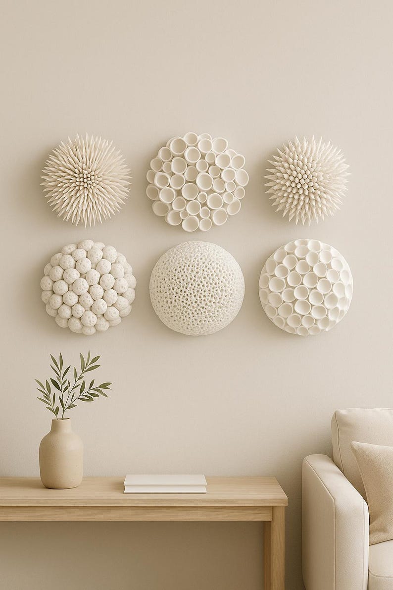 Hand-sculpted white polymer clay wall art featuring varied organic biophilic textures, from spiked spheres to cellular patterns. coastal minimalist, white interior design installation.