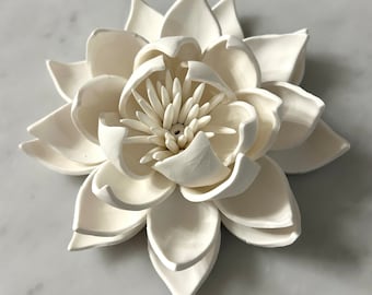 Op de afbeelding: Een witte keramische lotusbloem met een gedetailleerd centrum en meerdere lagen bloemblaadjes.