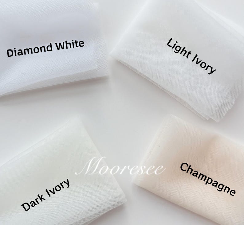 May include: Four fabric swatches in shades of white and ivory. The swatches are labeled "Diamond White", "Light Ivory", "Dark Ivory", and "Champagne". The fabric is a fine mesh, likely tulle, and is folded neatly. The word "Mooresee" is also visible.