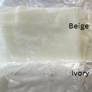 May include: Three fabric samples in white, beige, and ivory, each labeled with its color. The white and ivory fabrics feature a delicate leaf pattern. The fabrics are packaged in clear plastic.