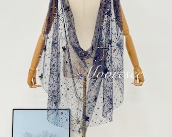 May include: A navy blue cape with a celestial design, featuring stars, moons, and other celestial elements. The cape is made of a sheer fabric and is embellished with sequins. The word "Moorssee" is visible on the bottom right.