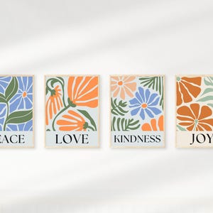 Four square floral prints with inspirational words. Each print features a light blue background with stylized orange and blue flowers and green leaves.  The words PEACE, LOVE, KINDNESS, and JOY are displayed at the bottom of each print respectively.