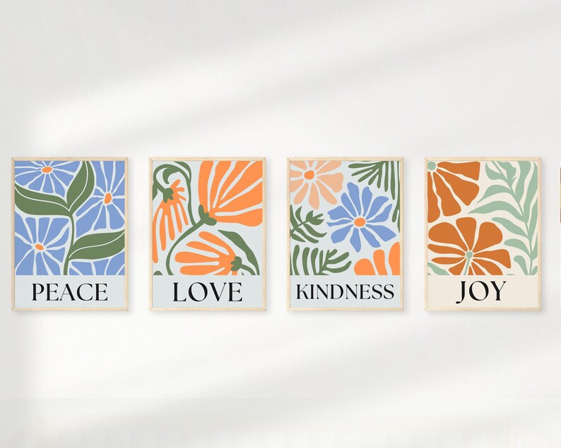 Four square floral prints with inspirational words. Each print features a light blue background with stylized orange and blue flowers and green leaves.  The words PEACE, LOVE, KINDNESS, and JOY are displayed at the bottom of each print respectively.