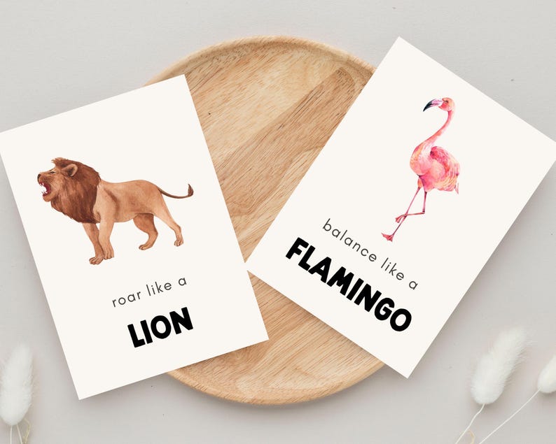 Set of two inspirational animal prints for kids with phrases ‘roar like a lion’ and ‘balance like a flamingo’ featuring watercolor illustrations and minimalist background.