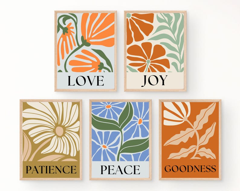 Five floral prints featuring various flower designs and colors, including orange, blue, and gold. Each print includes a word: LOVE, JOY, PATIENCE, PEACE, and GOODNESS. The prints are framed in light wood and have a minimalist aesthetic.
