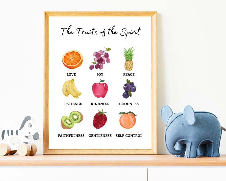 A framed print with the title 'The Fruits of the Spirit' and a list of nine fruits of the spirit with corresponding images. The fruits are love, joy, peace, patience, kindness, goodness, faithfulness, gentleness, and self-control. The images are of an orange, grapes, a pineapple, bananas, an apple, blueberries, kiwi, a strawberry, and a peach.