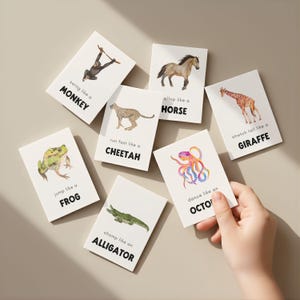 A collection of animal-themed flashcards with watercolor illustrations. Each card features an animal and an action, such as "swing like a monkey" or "run fast like a cheetah." The cards are white with black text and colorful animal images.