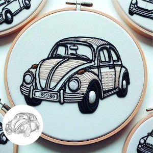 Peut inclure: Broderie d'art d'une voiture ancienne dans un cercle en bois. Le motif utilise du fil noir et beige sur fond blanc. La voiture a une plaque d'immatriculation avec le numéro "85089". La broderie est encadrée dans un cercle en bois.