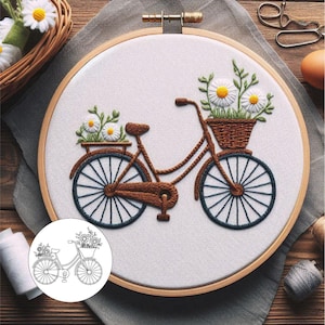 May include: A white embroidery hoop with a brown wooden frame. The hoop features a hand-stitched design of a bicycle with flowers in baskets. The bicycle is brown with black wheels and white flowers.