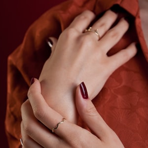 It is a wavy minimalist ring model. It is worn on the thumb or other fingers.