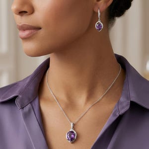 K&ouml;nnte beinhalten: Ein silberfarbenes Halsketten- und Ohrring-Set mit birnenf&ouml;rmigen, violetten Amethyst-Edelsteinen. Jedes Schmuckst&uuml;ck ist mit kleinen, klaren Pav&eacute;-Steinen entlang des Metallrahmens verziert und an einer zarten, silberfarbenen Kette befestigt.
