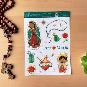 May include: A sheet of weatherproof vinyl stickers featuring Our Lady of Guadalupe, St. Juan Diego, a rosary, a cactus, a heart, and roses. The stickers are white with colorful illustrations and the text "Ave Maria".