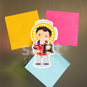 May include: A colorful sticker featuring a cartoon illustration of St. Carlo Acutis, a young man holding a laptop with a halo around his head. The sticker has the text "St. Carlo Acutis" and "@saintsprouts" on it.