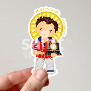 May include: A cartoon illustration of Saint Carlo Acutis, a young man with brown hair, wearing a red shirt, white pants, and a blue backpack. He is holding a laptop with a golden sun on the screen. The image is surrounded by a yellow halo and the text "St. Carlo Acutis" is written above him.
