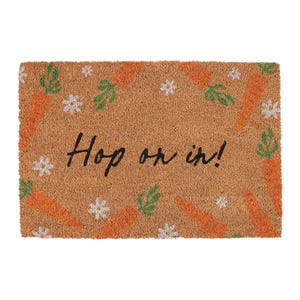 May include: A brown coir doormat with the text "Hop on in!" in black script. The doormat is decorated with orange carrots and green leaves.
